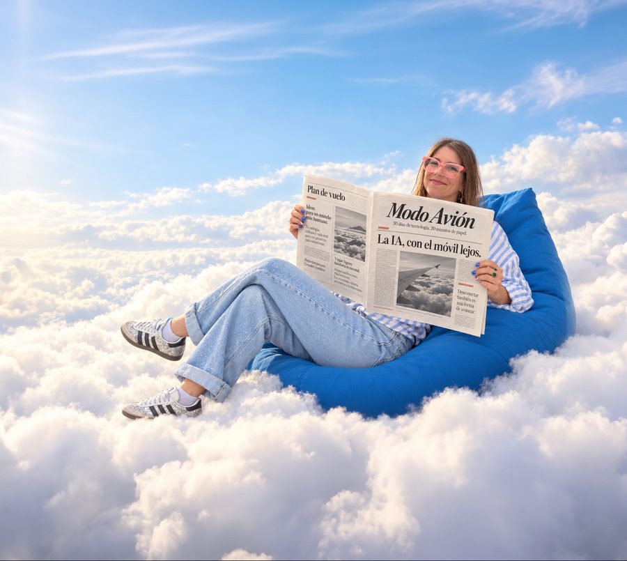 Julieta Bolullo leyendo la revista Modo Avión sentada en un puf azul sobre las nubes